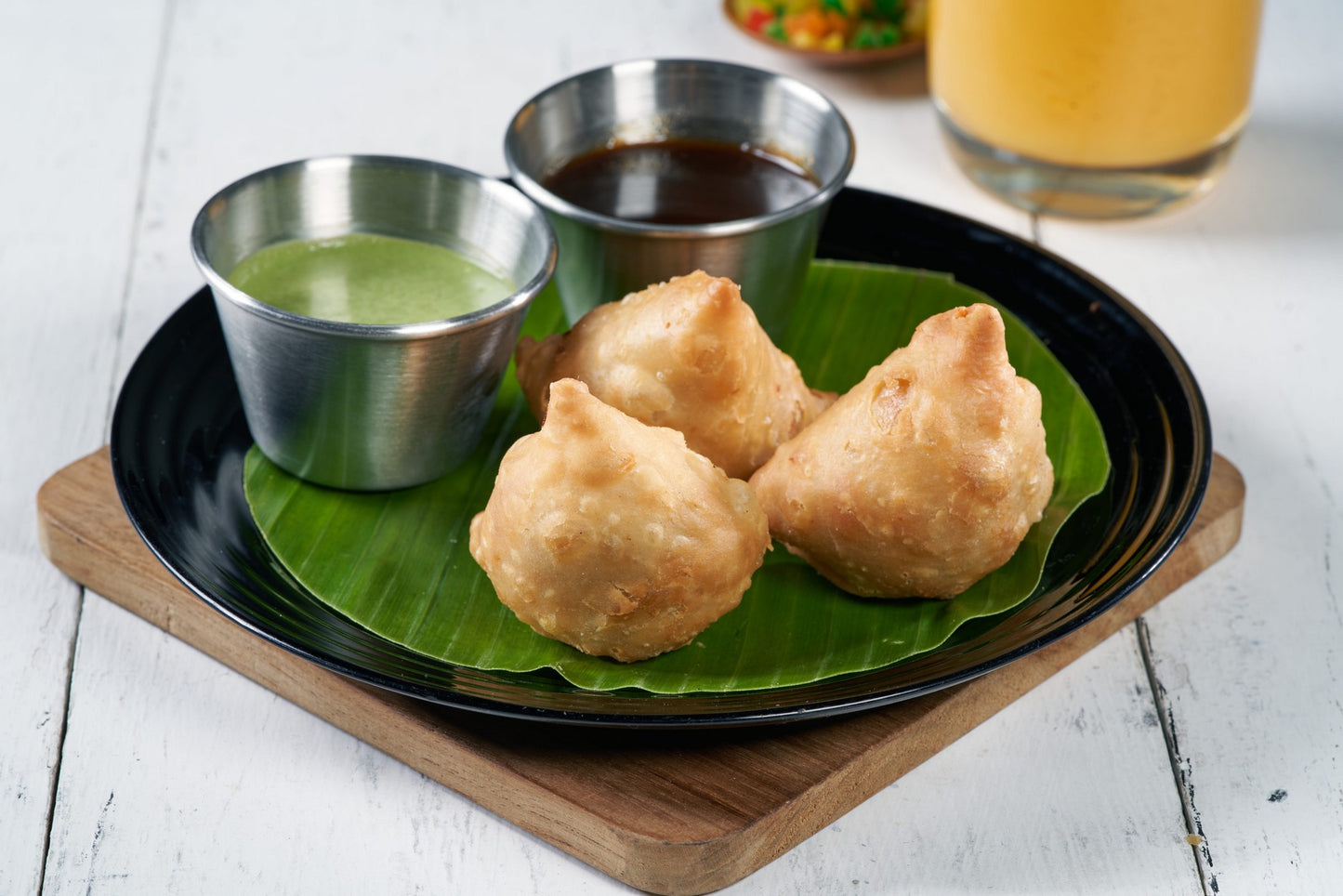 A plate of crispy Samosas, a traditional Indian savory pastry filled with potatoes and green peas