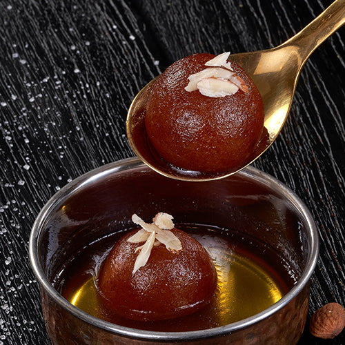 Gulab Jamun, a classic Indian dessert with a soft, spongy texture and a sweet, syrupy coating