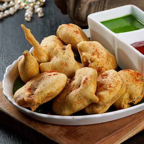 A plate of crispy Mix Vegetable Pakoda, a savory Indian fritter made with sliced vegetables and a spicy lentil batter