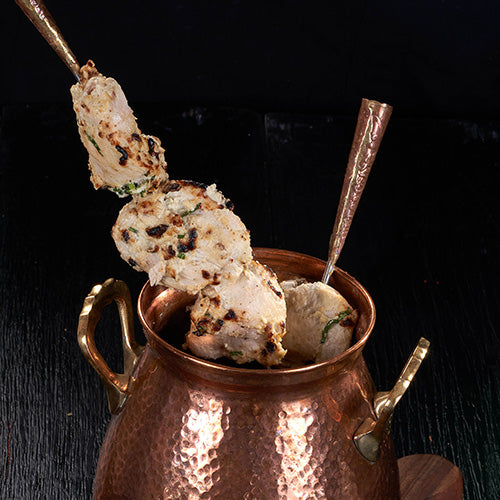 Tender pieces of Murgh Malai Tikka, marinated in yogurt, cheese, and garlic, at an Indian Restaurant