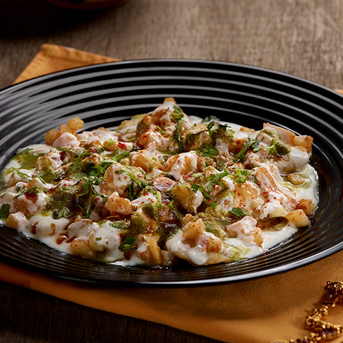 A colorful Papdi Chaat, a crispy cracker topped with savory chickpeas, yogurt, and chutneys