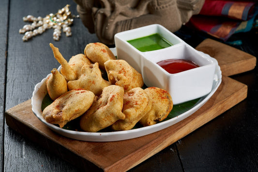 A plate of crispy Mix Vegetable Pakoda, a savory Indian fritter made with sliced vegetables and a spicy lentil batter