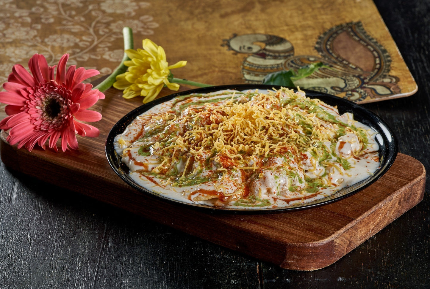 A colorful Papdi Chaat, a crispy cracker topped with savory chickpeas, yogurt, and chutneys