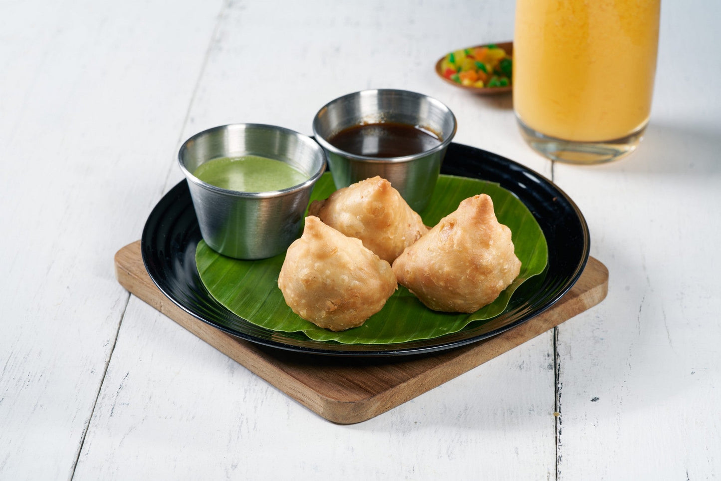 A plate of crispy Samosas, a traditional Indian savory pastry filled with potatoes and green peas