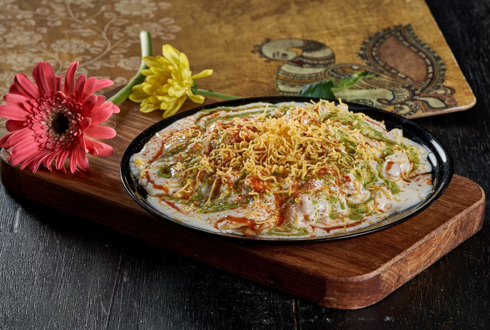 A colorful Papdi Chaat, a crispy cracker topped with savory chickpeas, yogurt, and chutneys