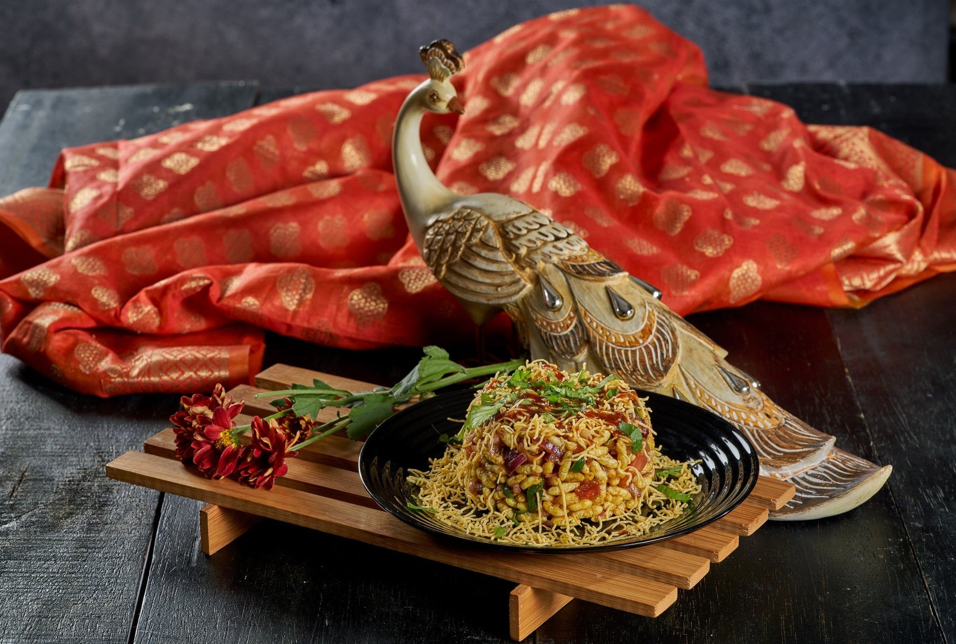 A colorful plate of Bhel Puri, a savory and refreshing Indian snack made with puffed rice, vegetables, and chutneys