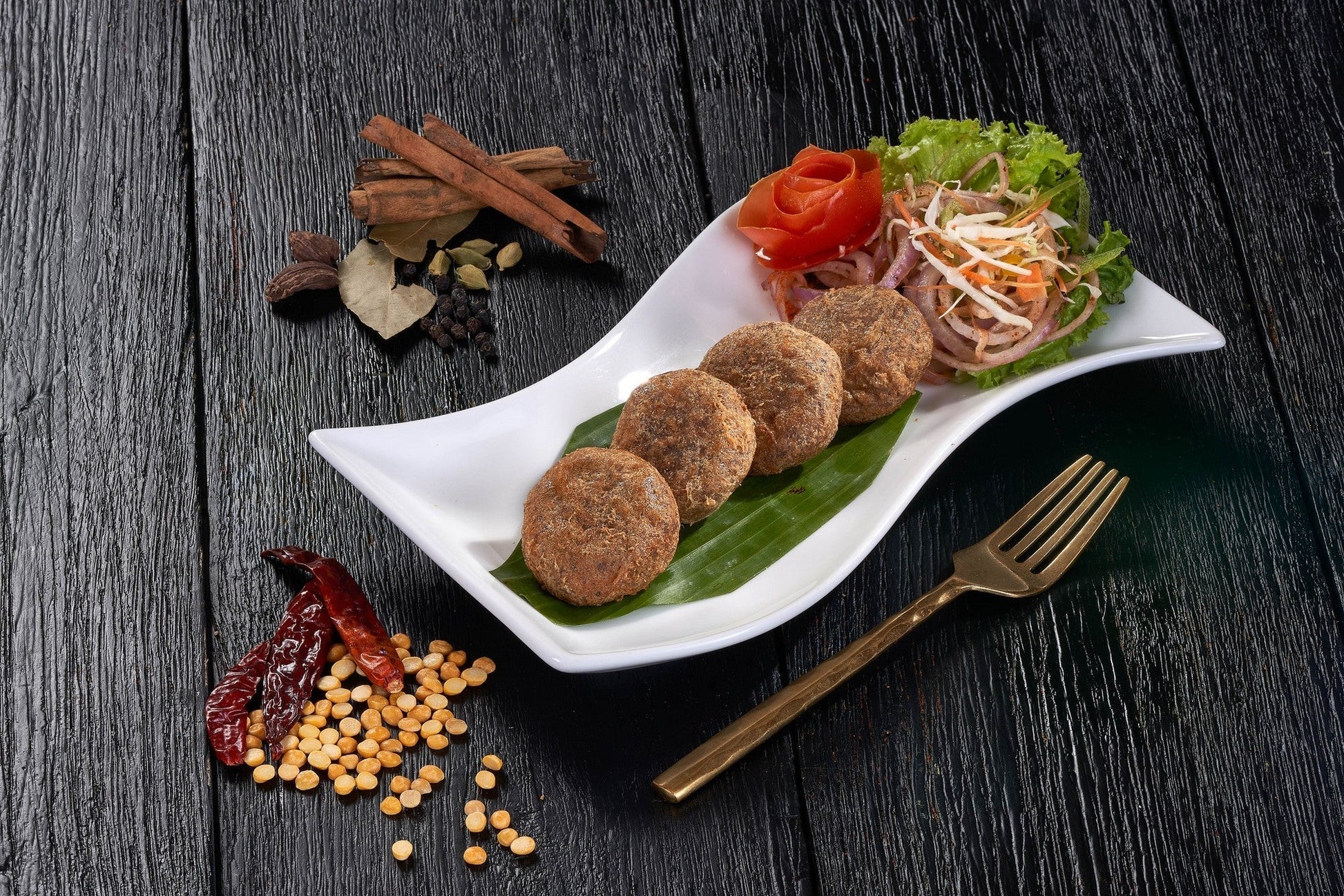 A plate of crispy Shami Kebabs, savory patties made with minced lamb and lentil